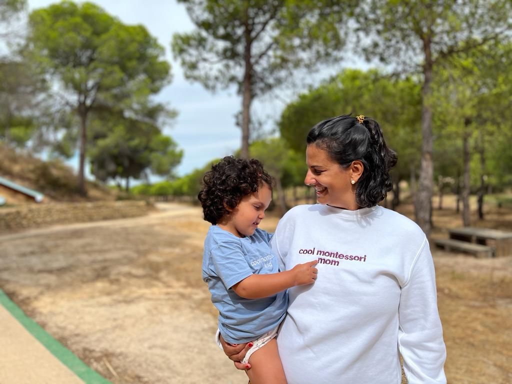 Flavia founder and maker of yudo montessori, a shop about modern Montessori language cards for kids, with her daughter displaying a cool montessori shirt