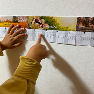 Little hand pointing to a linear calendar display on a wall