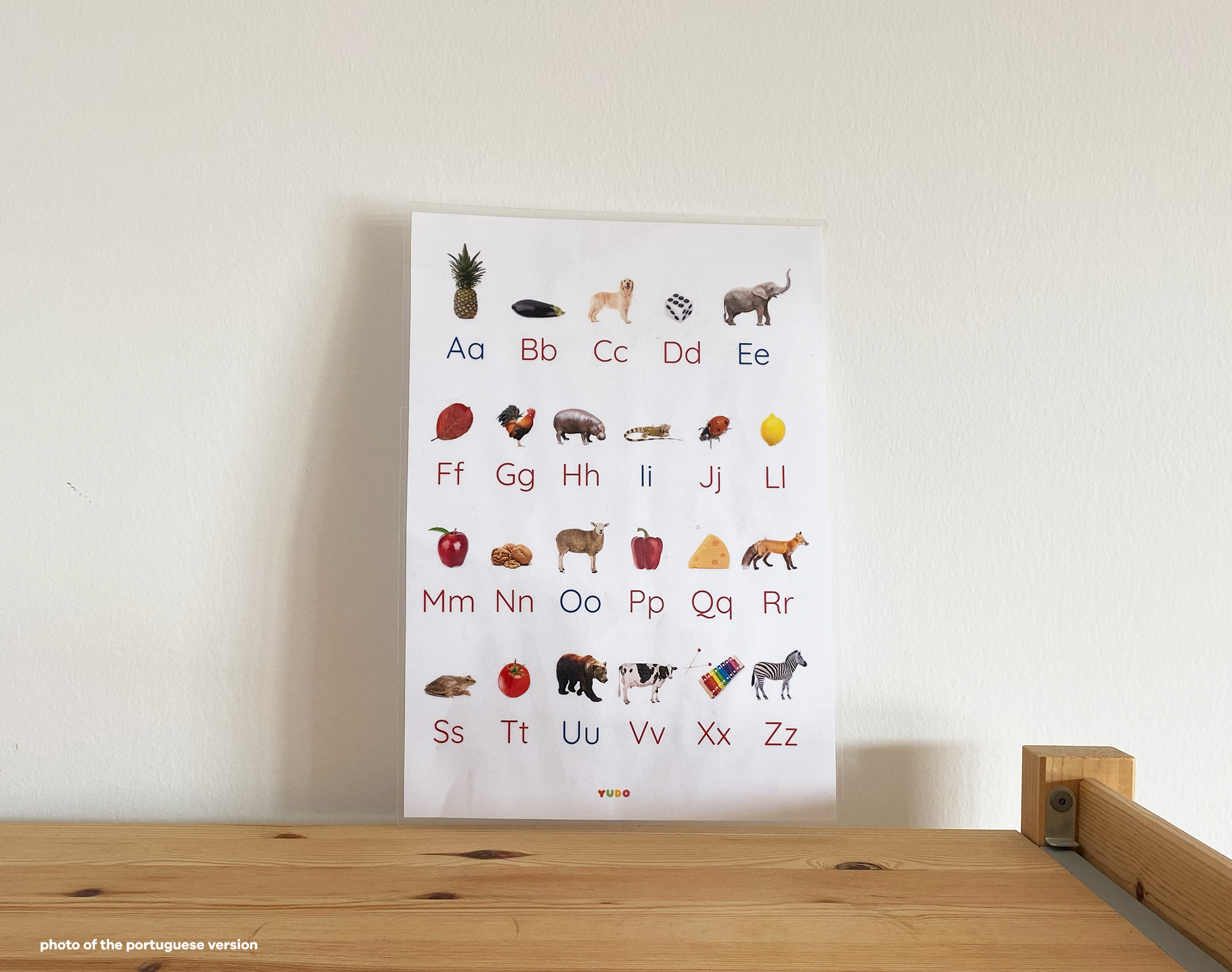 Montessori alphabet poster displayed on a shelf in a learning space
