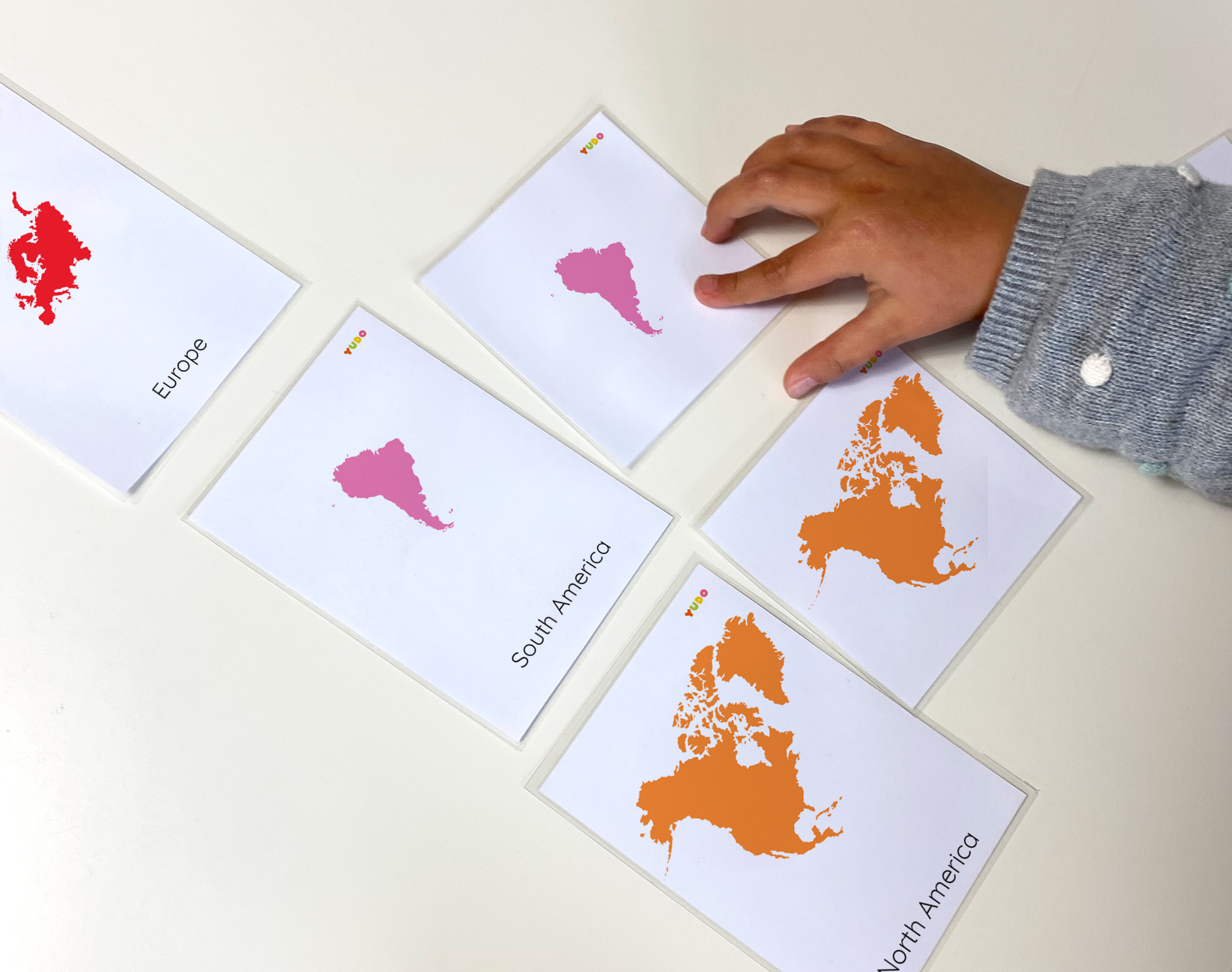 Child using Montessori continents 3-part cards matching activity