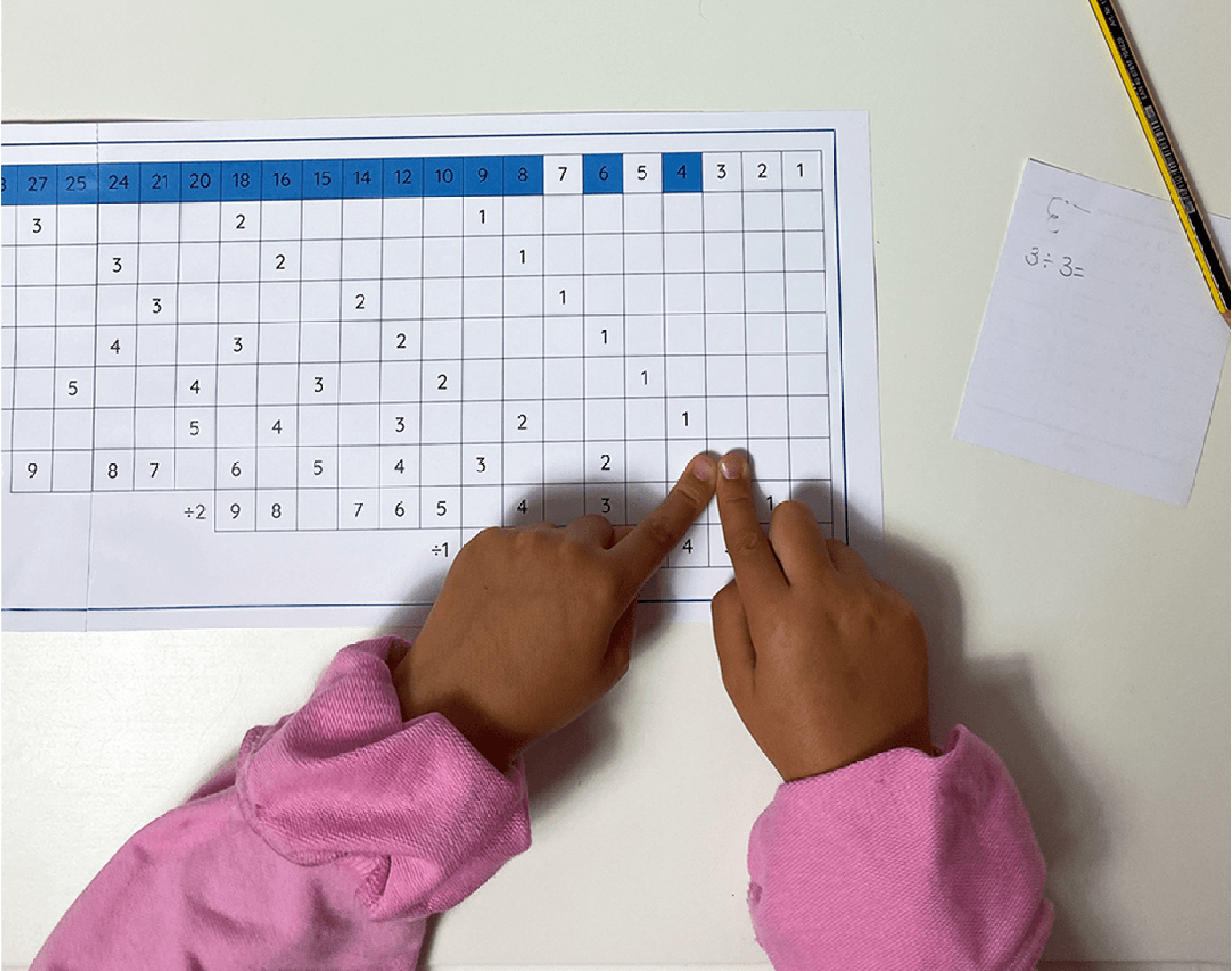 Child completing a Montessori addition working chart activity